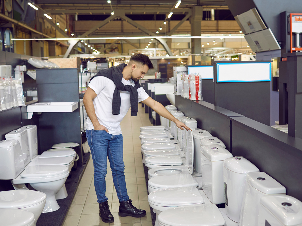Image of a man in a store looking at toilets.